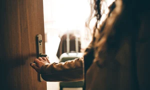 Femeie care iese pe usa casei FOTO Shutterstock 