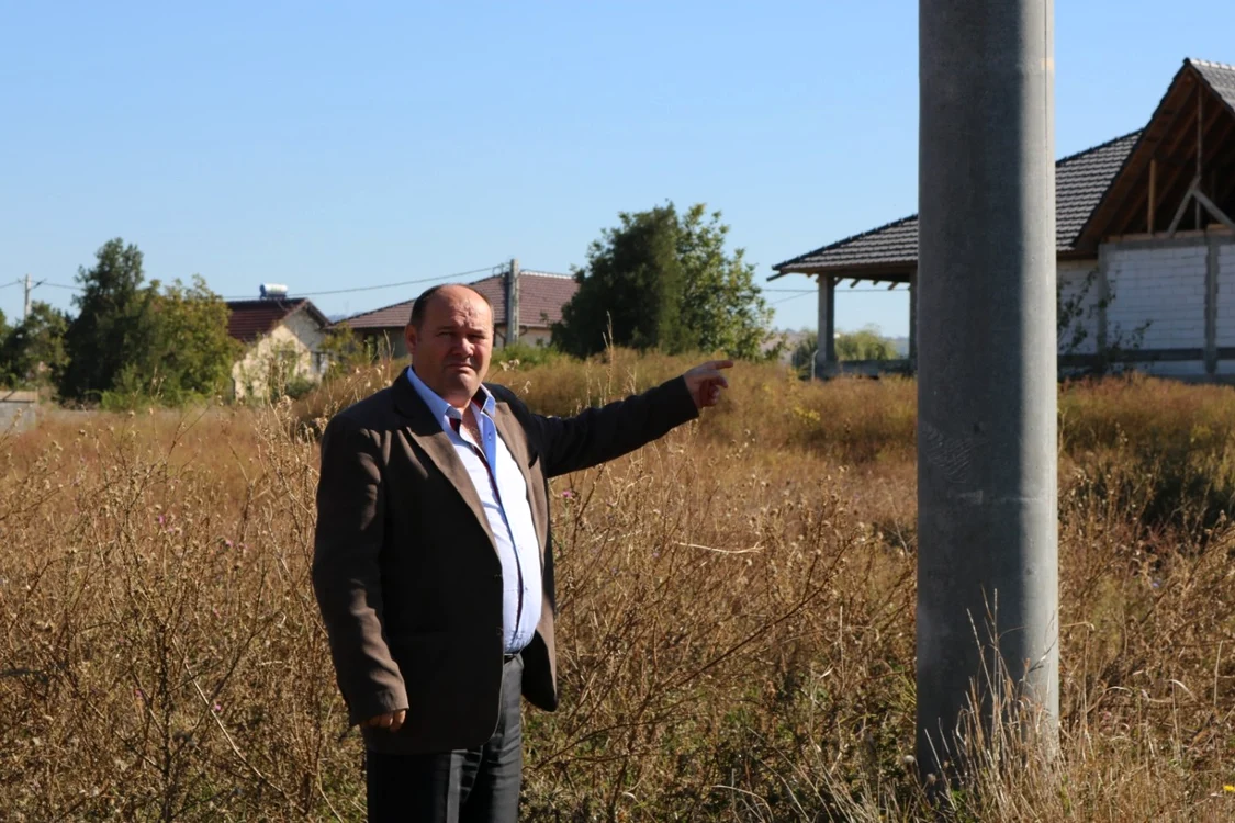 Mihai Munteanu arată stâlpul care îi disturbă proprietatea sa de la Şimian FOTO Alexandra Georgescu
