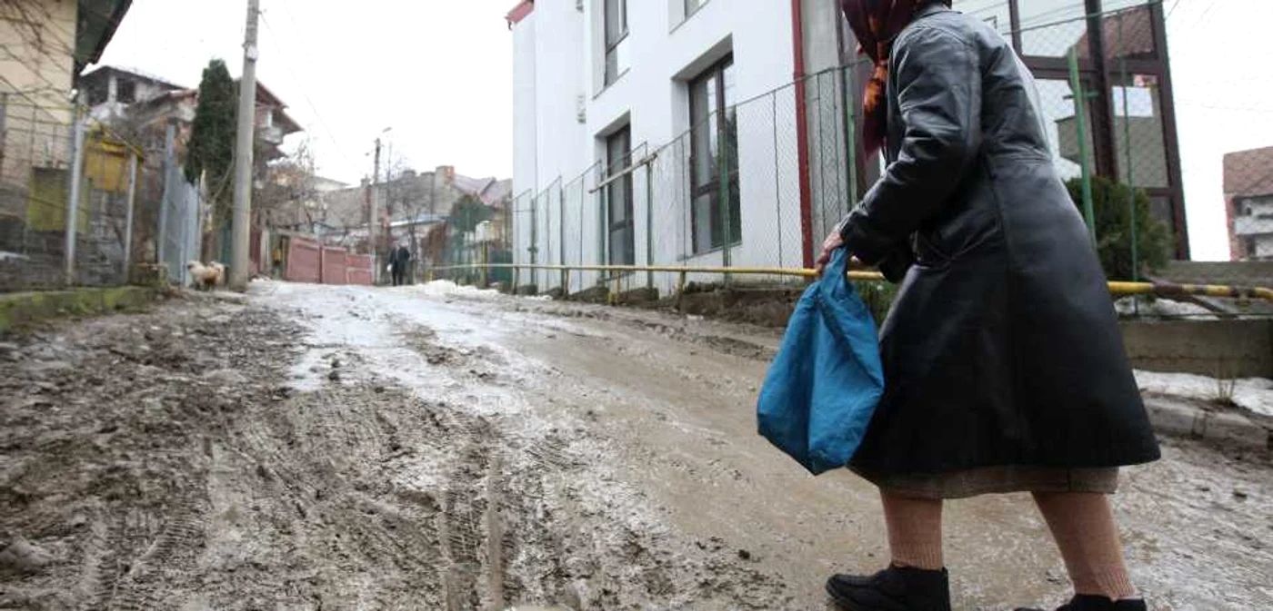 Pe strada Florilor, situată în zona fostei autogări, noroiul şi bălţile îi încurcă pe trecători.