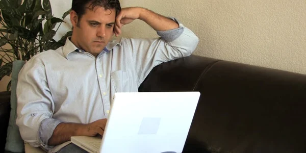 barbat se uita la laptop
