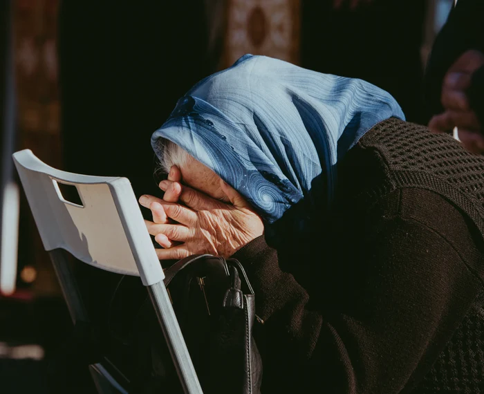 Bătrână rugându-se în timpul slujbei, la Hramul Sfintei Parascheva. FOTO Andrei Luca