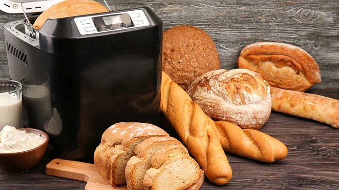 Mașină de pâine înconjurată de ingrediente și produsele preparate Sursă Plintuss