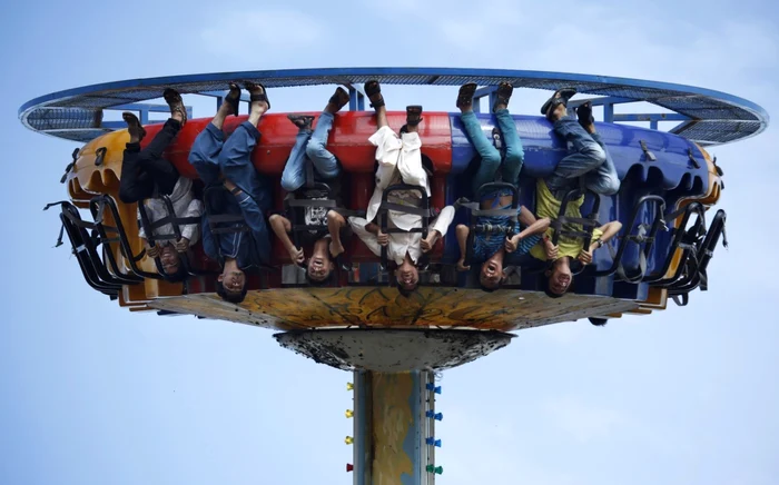 Tineri se manifestă zgomotos în timp ce se dau într-un carusel într-un parc din Rawalpindi Pakistan FOTO AP