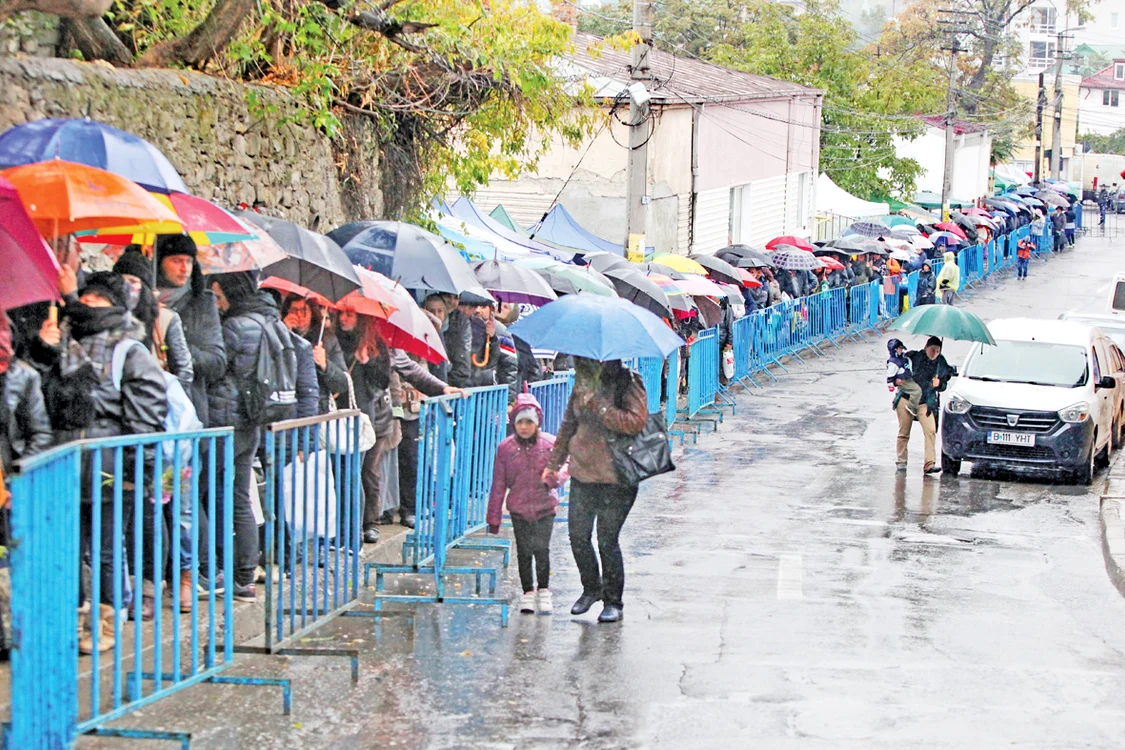 Credincioşii s-au adăpostit de ploaia mocănească sub umbrele