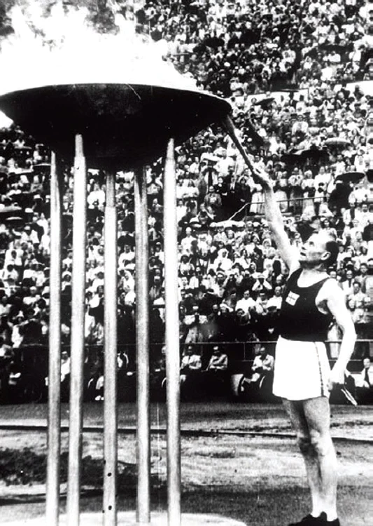 Alergătorul Paavo Nurmi,  supranumit şi „Finlandezul zburător”,  aprinde flacăra olimpică la Helsinki,  în 1952