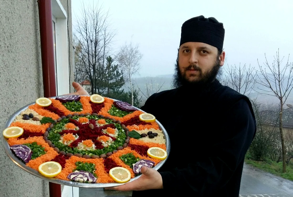 
    Călugărul Efrem Bandarică şi una dintre operele sale de artă din bucătărieFotografii: Arhiva personală Efrem Bandarică  