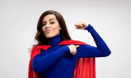 confident caucasian superhero girl with red cape tenses points biceps white jpg
