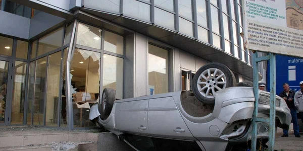 Autovehiculul s-a răsturnat şi a rămas blocat între o clădire şi un panou publicitar