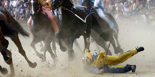 Un călăreţ cade în timpul tradiţionalei curse de cai Palio di Siena