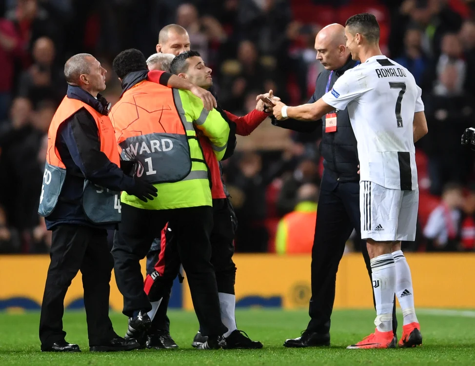 Ronaldo a pus mâna pe telefonul exibiţionistului îmbrăcat în tricoul său cu numărul 7 de pe vremuri şi l-a pus să zâmbească pentru că urmează fotografia