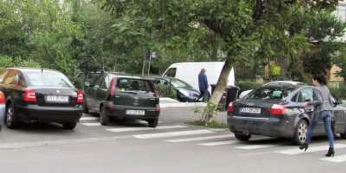 Pietonii care traversează strada Maramureş sunt nevoiţi să ocolească maşinile parcate pe trecerea de pietoni