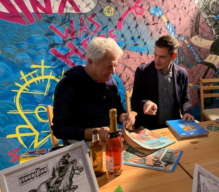 Ilustratorul Valentin Tănase răzfoind diverse reviste pe care le-a ilustrat