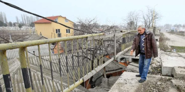 Mihai Drăceanu arată de unde s-au desprins bucăţile de beton care i-au căzut în curte  