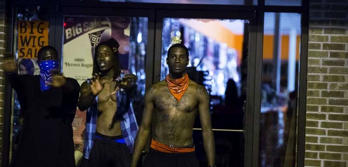 Protestatari care încearcă să împiedice vandalizarea unui magazin din Ferguson, Missouri, orăşelul american unde a fost împuşcat mortal adolescentul de culoare FOTO Reuters