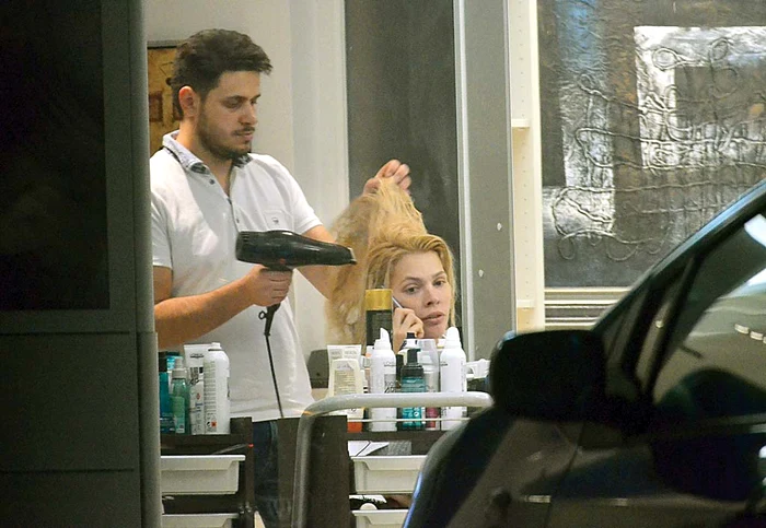 
    Alina şi-a văzut de vorbit şi în timp ce  era uscată la părFoto: Mihai Caliu  