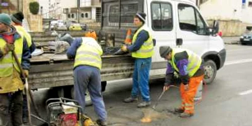 Muncitorii DADP usucă gropile străzilor cu butelia cu gaz