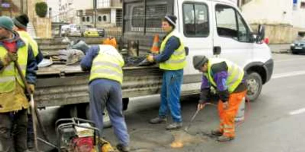 Muncitorii DADP usucă gropile străzilor cu butelia cu gaz
