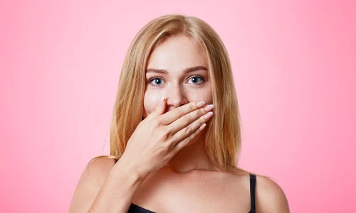 plesant looking light haired female dressed casually covers mouth with hand tries keep silent tell secret isolated pink wall people beauty body language concept jpg