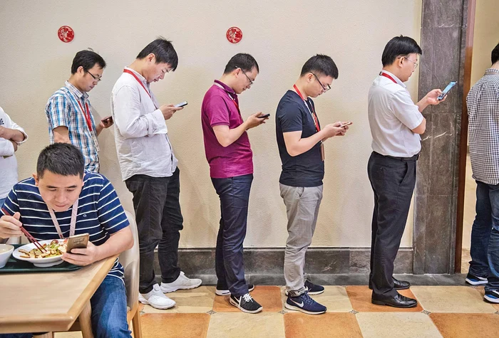 Angajații nu-și dezlipesc ochii de telefoane nici când stau la coada de la cantină