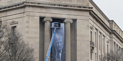 banner uriaș cu fața președintelui Donald Trump și mesajul „Make America Safe Again” pe fațada sediului Departamentului de Justiție din Washington FOTO: X/@WUTangKids