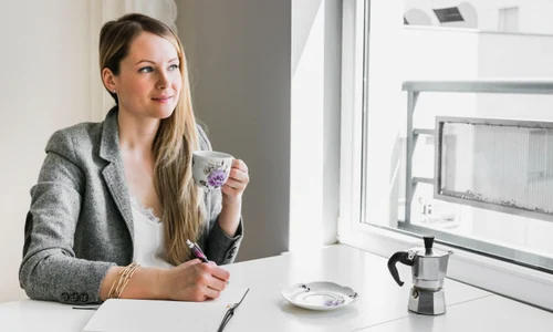 femeie care bea cafea la birou jpg