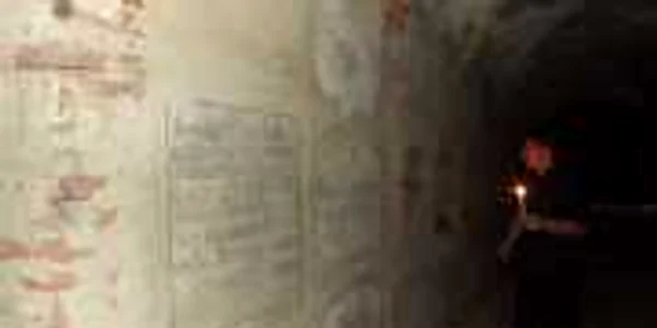 Preotul Teodor Lazăr cu o lumânare în mână,  în cripta de sub biserica unde slujeşte (foto: cluj.travel)