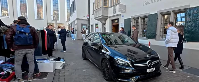 Oamenii coboară din Mercedes pentru a-și cumpăra haine second hand. FOTO: captură Cosmin Avram.