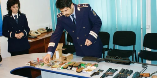Poliţiştii au înşirat pe masă pistoalele şi gloanţele confiscate