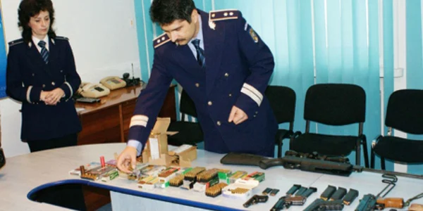 Poliţiştii au înşirat pe masă pistoalele şi gloanţele confiscate