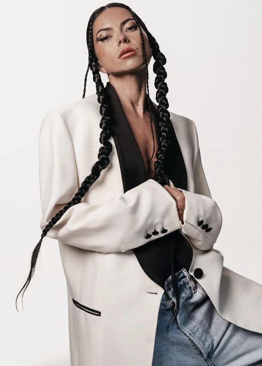 Inna, cu părul împletit, îmbrăcată într-un sacou alb - negru