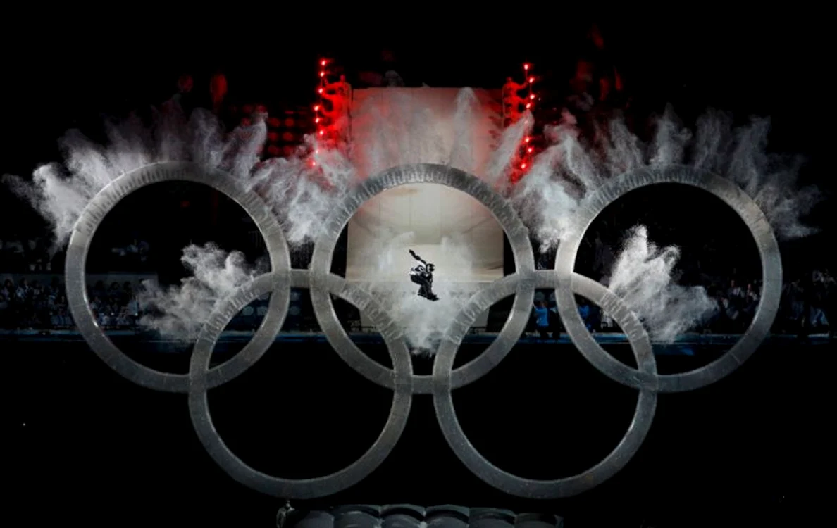 Un  snowboarder zboară prin faţa cercurilor olimpice în timpul festivităţii de deschidere a Olimpiadei de iarnă de la Vancouver, 12 februarie (Foto: Reuters / David Gray)