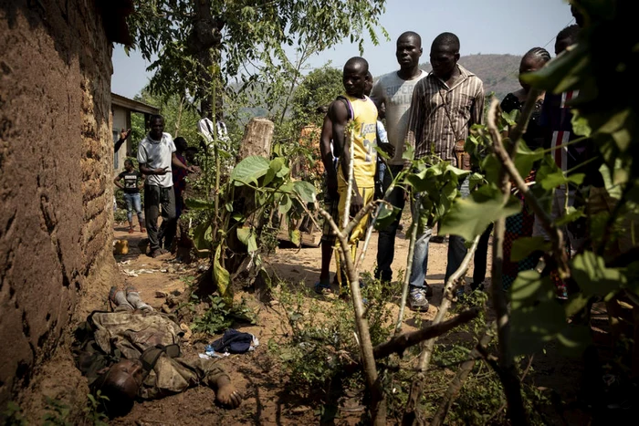 Locuitorii unui sat din Republica Centrafricană se uită la cadavrul unui membru al forţelor rebele FOTO EPA-EFE