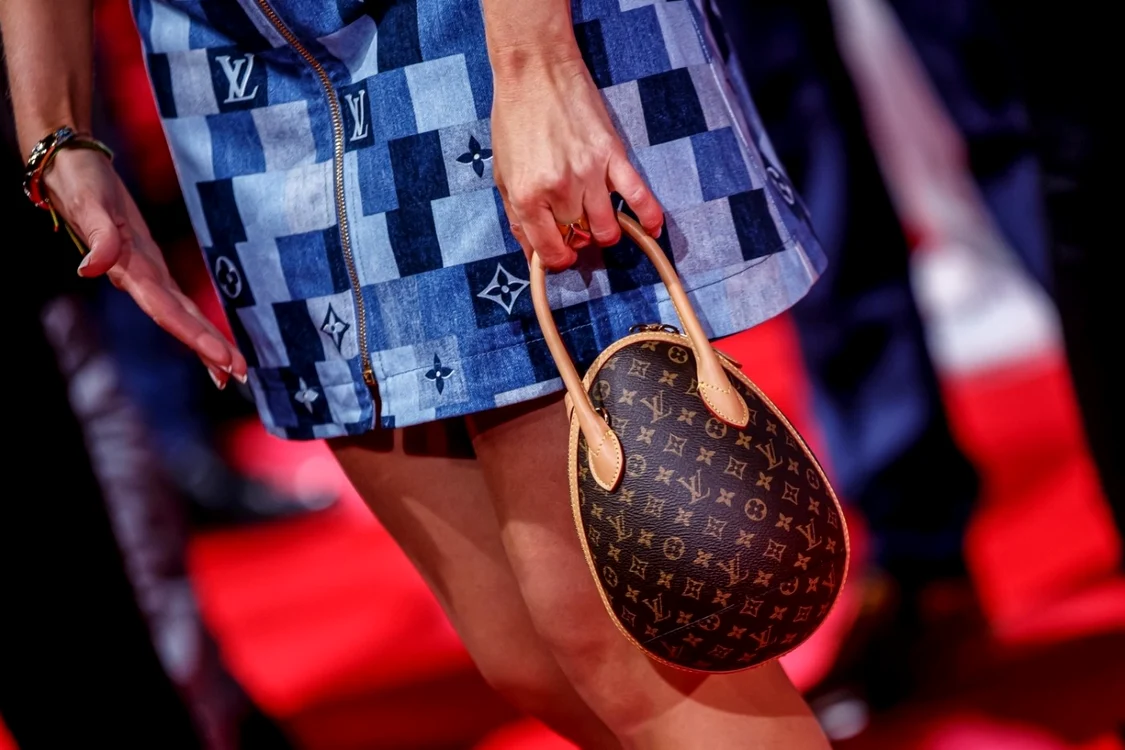 O tânără care ține în mână o geantă Louis Vuitton