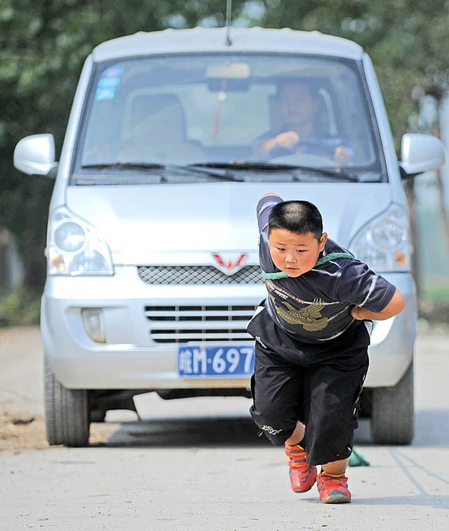 
    Yang Jinlong trage după  el maşini  de 2 tone  