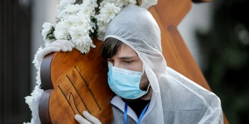 Voluntari în combinezoane de protecţie la slujba din Vinerea Marea