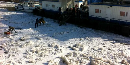 Cară pâinea pe Dunărea îngheţată