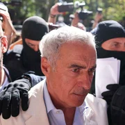 Călin Georgescu este însoțit de ofițeri de poliție la sediul DIICOT pentru audiere, în București. FOTO Inquam Photos / George Călin