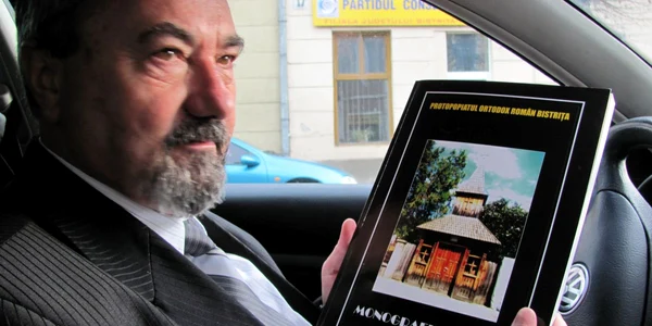 Protopopul Alexandru Vidican arată prima ediţie a monografiei, din 2008
