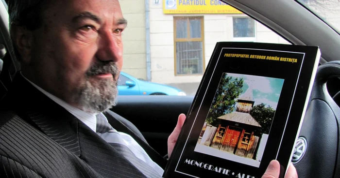 Protopopul Alexandru Vidican arată prima ediţie a monografiei, din 2008