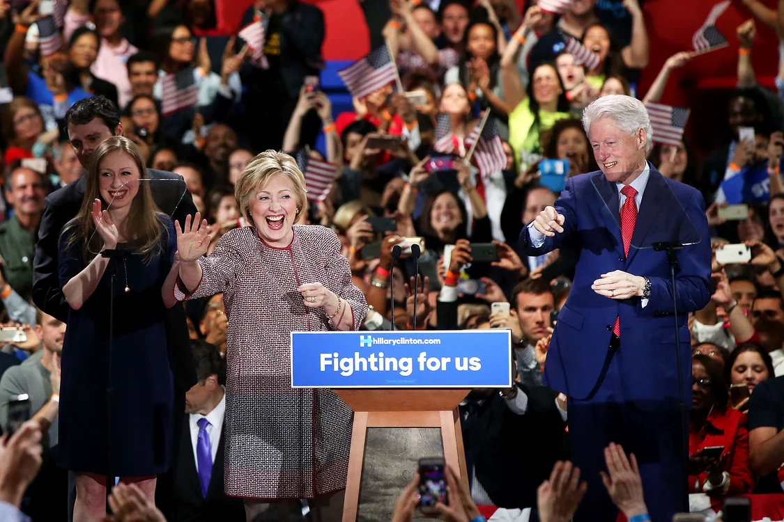 Hillary CLinton, în sacoul Armani de peste 12.000 de dolari, alături de soțul ei, Bill CLinton, și de fiica ei, Chelsea