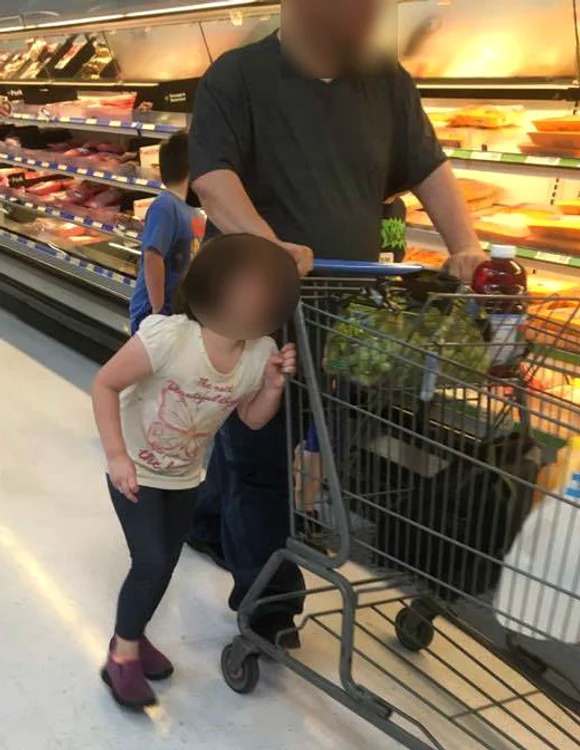 Bărbatul a înfășurat părul fetiței pe mânerul căruțului, mergând cu ea așa prin supermarket