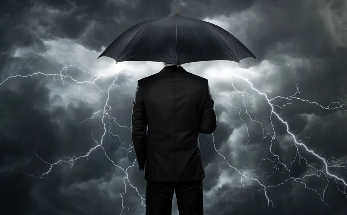 Un bărbat cu o umbrelă pe un fundal de cer noros brăzdat de fulgere