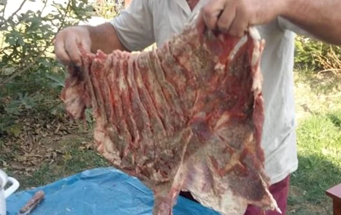 Imagine cu un teleormănean preparând pastrama de oaie  FOTO: Adevărul