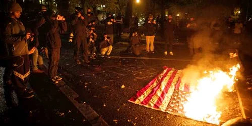 Manifestanţi ard steaguri americane în Portland în contextul unei curse strânse între Trump şi Biden FOTO EPA-EFE