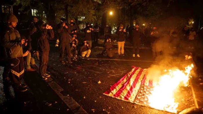 Manifestanţi ard steaguri americane în Portland în contextul unei curse strânse între Trump şi Biden FOTO EPA-EFE
