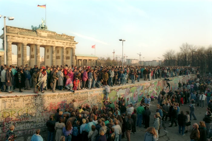 Oamenii se cațără pe Zidul Berlinului în fața Porții Brandenburg FOTO GettyImages