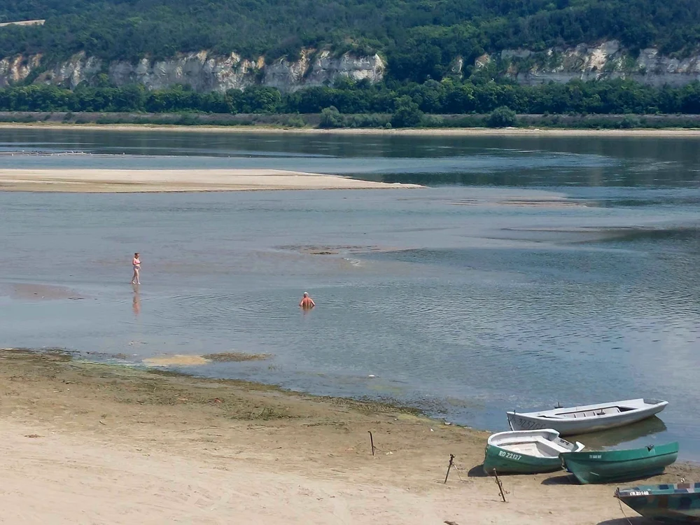 Un om merge în picioare în Dunărea secată