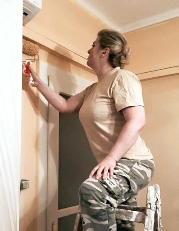 Kolinda Grabar-Kitarovic poartă pantaloni de camuflaj când își zugrăvește apartamentul