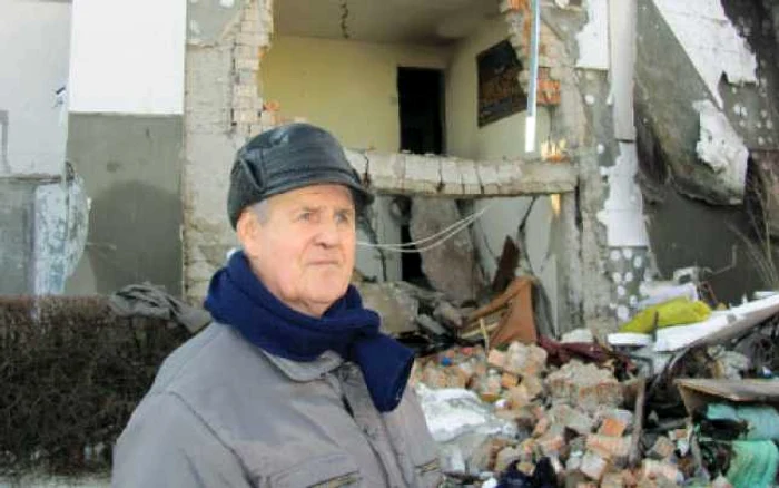 Ion Leonte (79 de ani), în faţa apartamentului său complet distrus