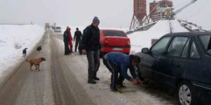  Conducătorii auto şi-au montat lanţuri înainte de a începe urcuşul spre staţiune
